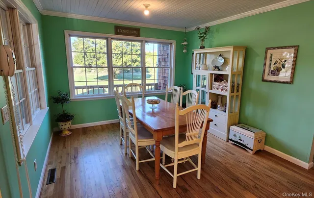 a view of a dining room with furniture window and wooden floor