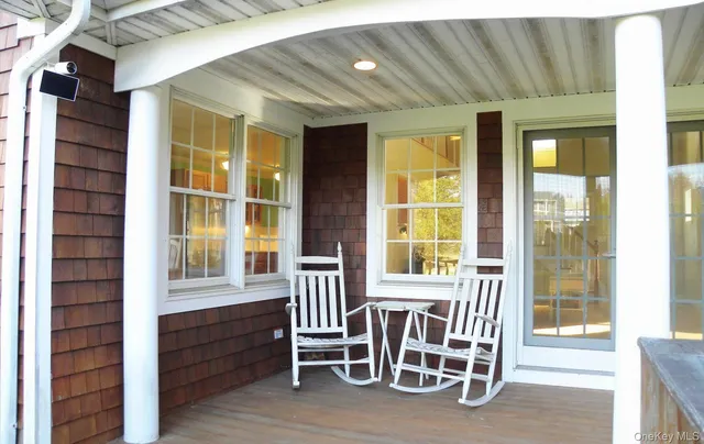 a porch area with a table and chairs