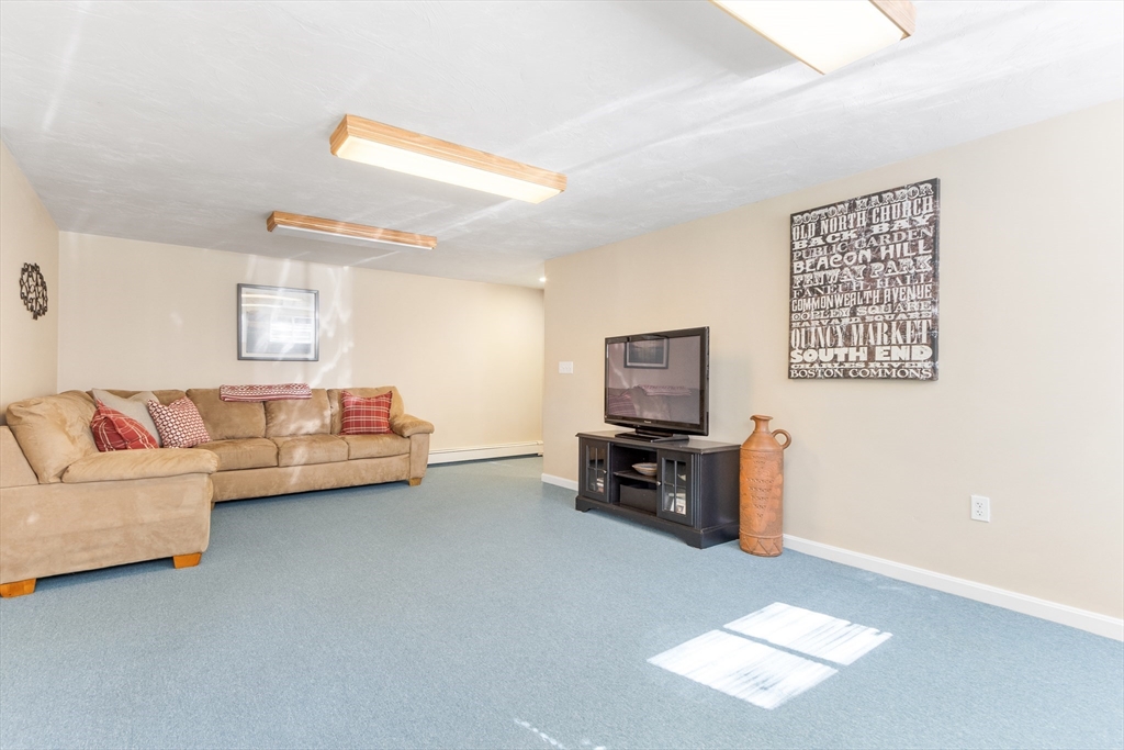 55 Berkshire Road Needham, MA 02492 - Photo 25 of 33 a living room with furniture and a flat screen tv