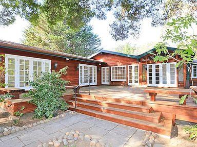a view of a house with a large windows and large tree