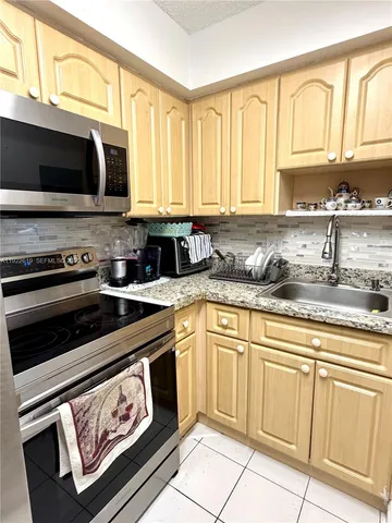 a kitchen with granite countertop a refrigerator and a sink
