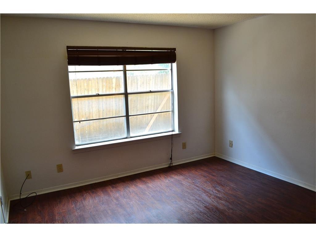 1107 North Locust Street, Unit 2 Denton, TX 76201 - Photo 3 of 8 a view of an empty room with wooden floor and a window