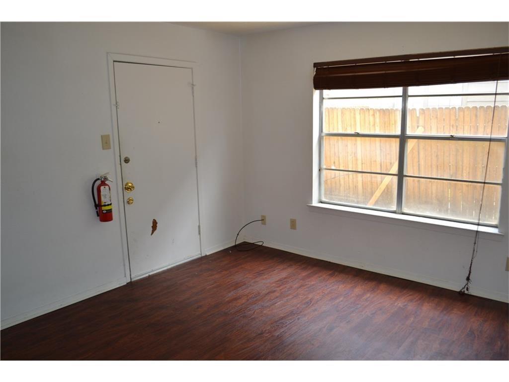 1107 North Locust Street, Unit 2 Denton, TX 76201 - Photo 4 of 8 a view of an empty room with wooden floor and windows
