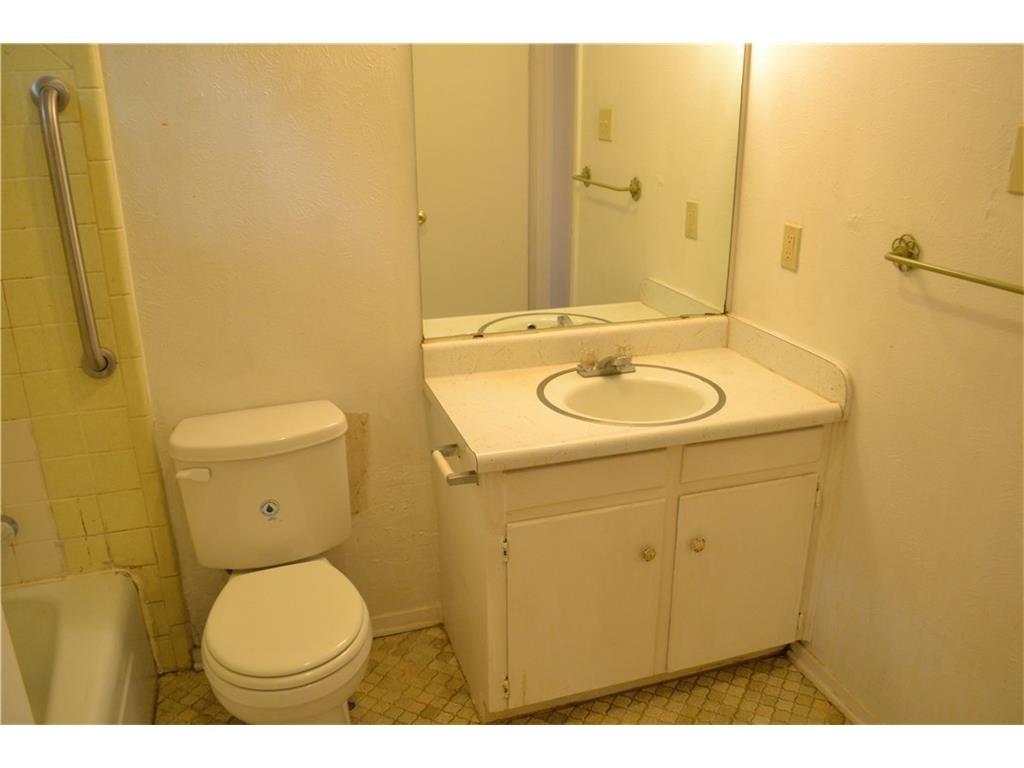 1107 North Locust Street, Unit 2 Denton, TX 76201 - Photo 6 of 8 a bathroom with a toilet sink and mirror