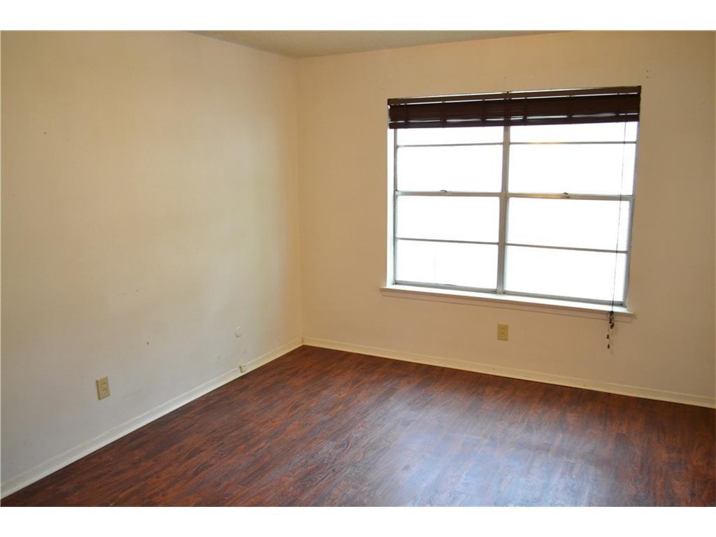 1107 North Locust Street, Unit 2 Denton, TX 76201 - Photo 7 of 8 an empty room with wooden floor and windows