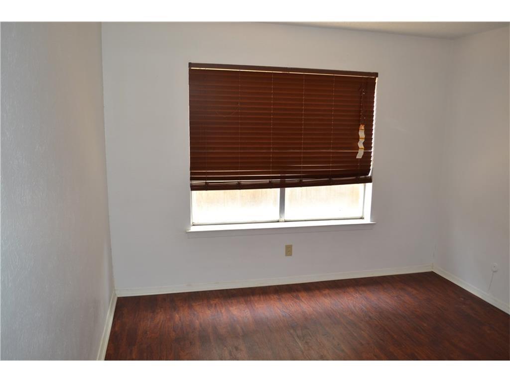 1107 North Locust Street, Unit 2 Denton, TX 76201 - Photo 8 of 8 a view of an empty room with wooden floor and a window