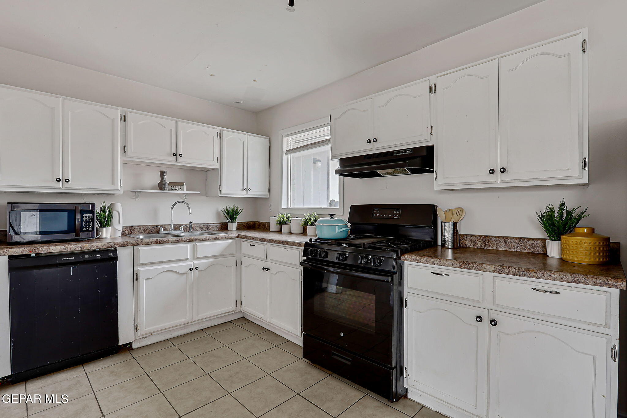 4956 Rutherford Drive El Paso, TX 79924 - Photo 11 of 41 a kitchen with granite countertop white cabinets and black appliances