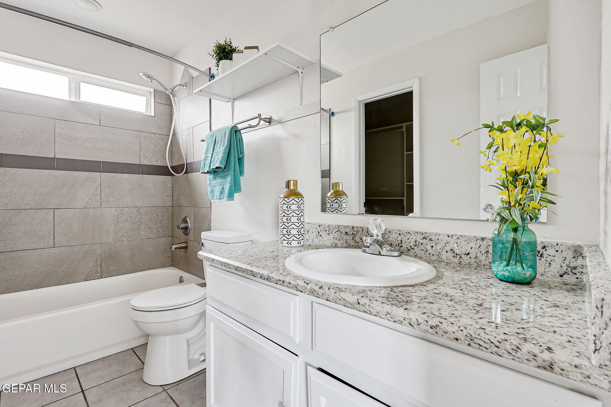 4956 Rutherford Drive El Paso, TX 79924 - Photo 19 of 41 a bathroom with a granite countertop sink a toilet and shower