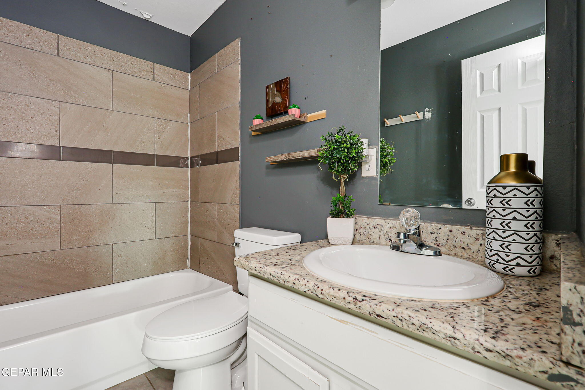 4956 Rutherford Drive El Paso, TX 79924 - Photo 25 of 41 a bathroom with a granite countertop sink and a mirror