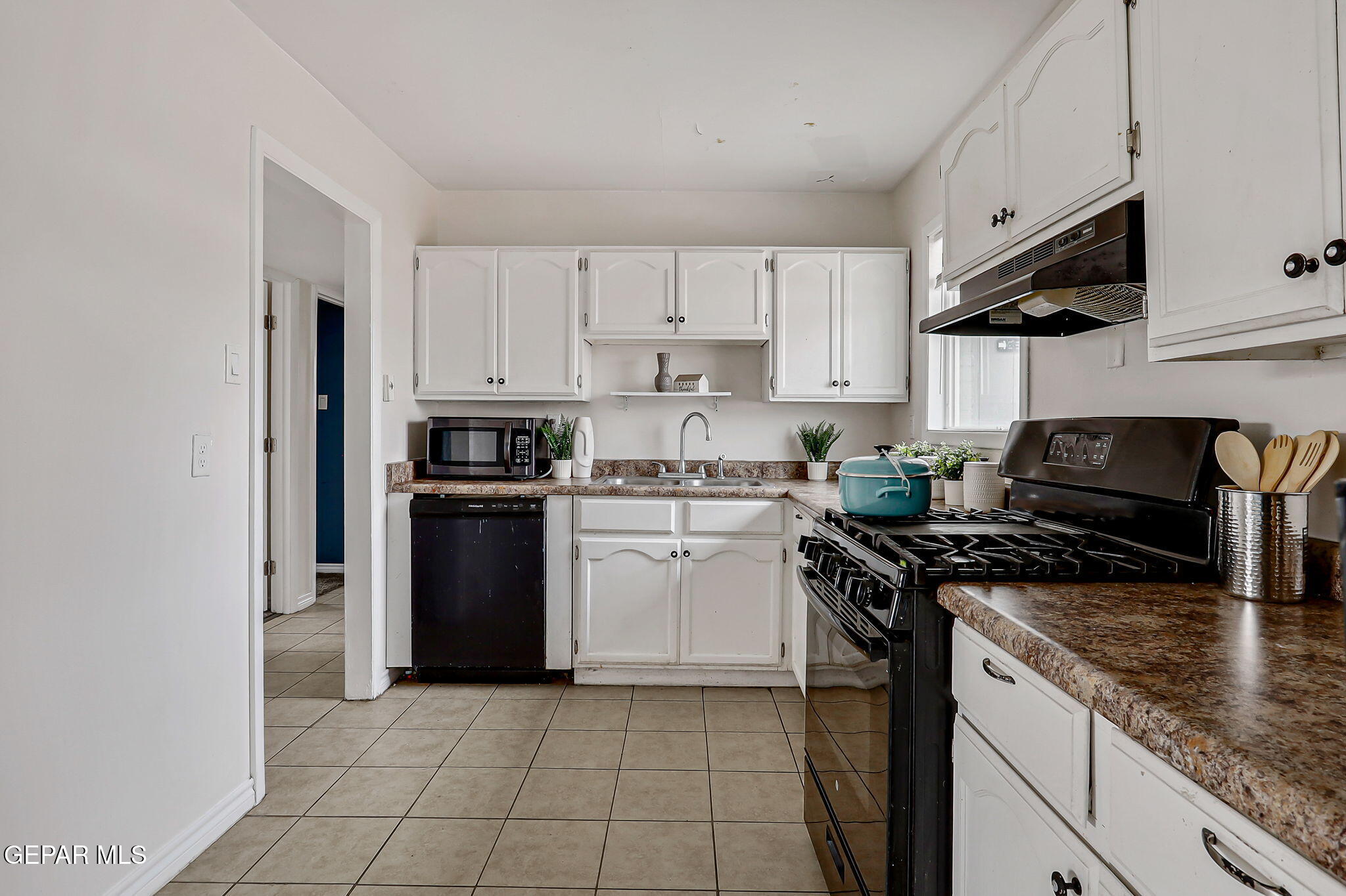 4956 Rutherford Drive El Paso, TX 79924 - Photo 10 of 41 a kitchen with granite countertop a stove sink and cabinets