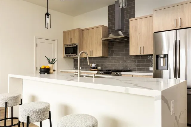 a kitchen with stainless steel appliances granite countertop a sink and a refrigerator