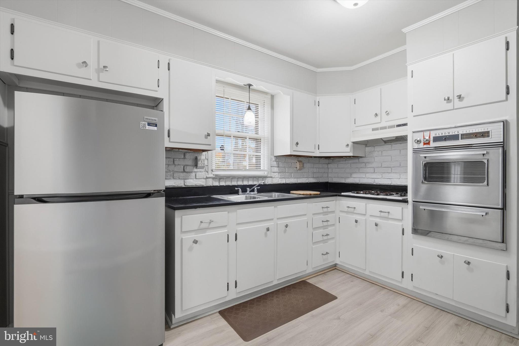 697 West Maple Road Linthicum Heights, MD 21090 - Photo 13 of 36 a kitchen with granite countertop white cabinets and refrigerator