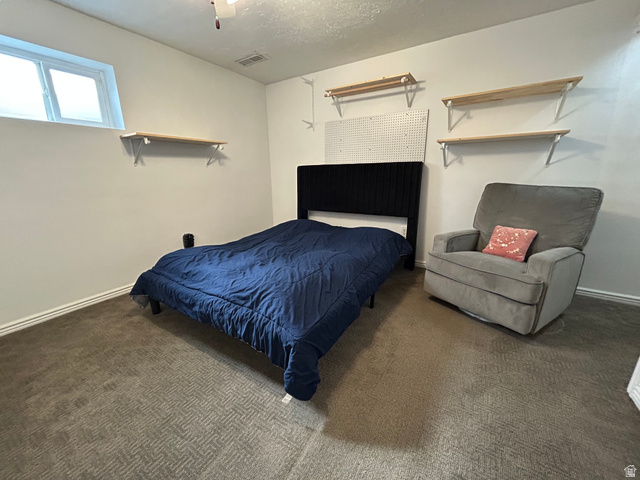 7659 State Street Midvale, UT 84047 - Photo 18 of 33 Bedroom featuring dark carpet and a textured ceiling