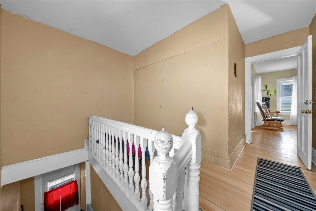 103 Ash Street Nashua, NH 03060 - Photo 3 of 36 a view of a livingroom with wooden floor and stairs