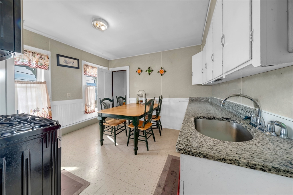 103 Ash Street Nashua, NH 03060 - Photo 5 of 36 a kitchen with stainless steel appliances granite countertop a sink a stove and island