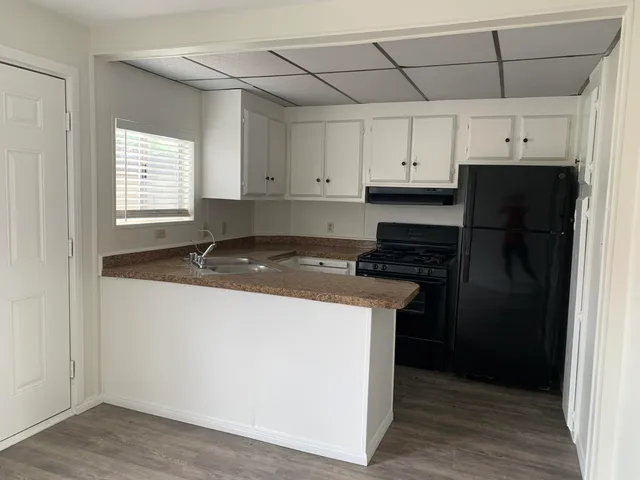 a kitchen with a refrigerator and a stove top oven