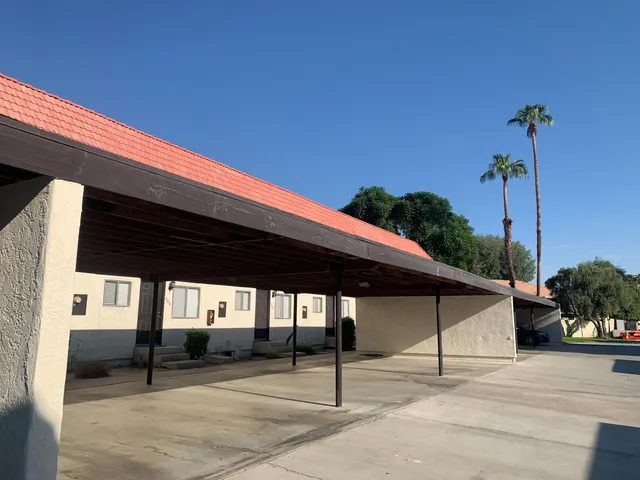 a patio with table and chairs and potted plants