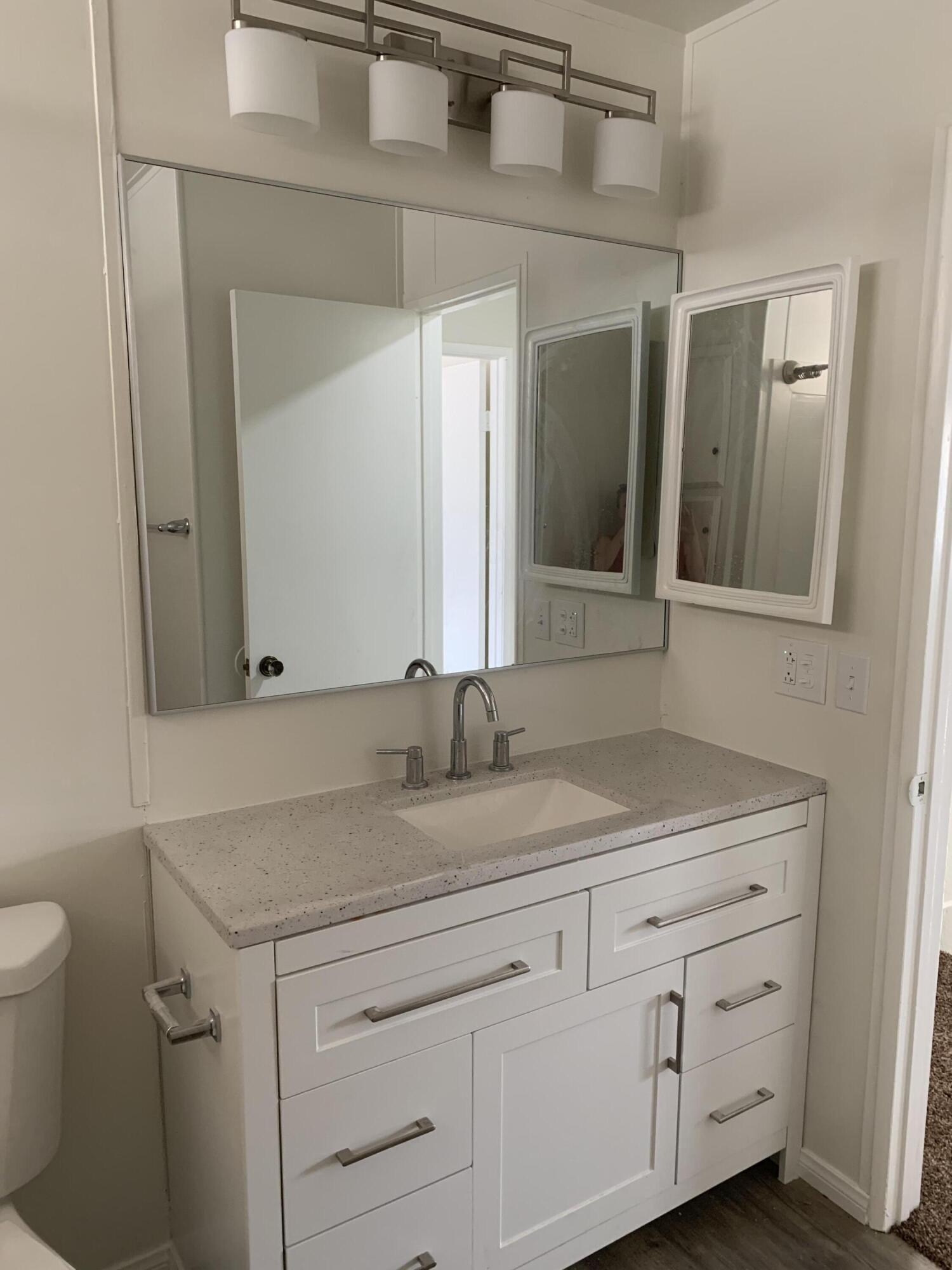40225 Harris Lane, Unit 304 Palm Desert, CA 92211 - Photo 7 of 14 a bathroom with a granite countertop sink mirror and toilet