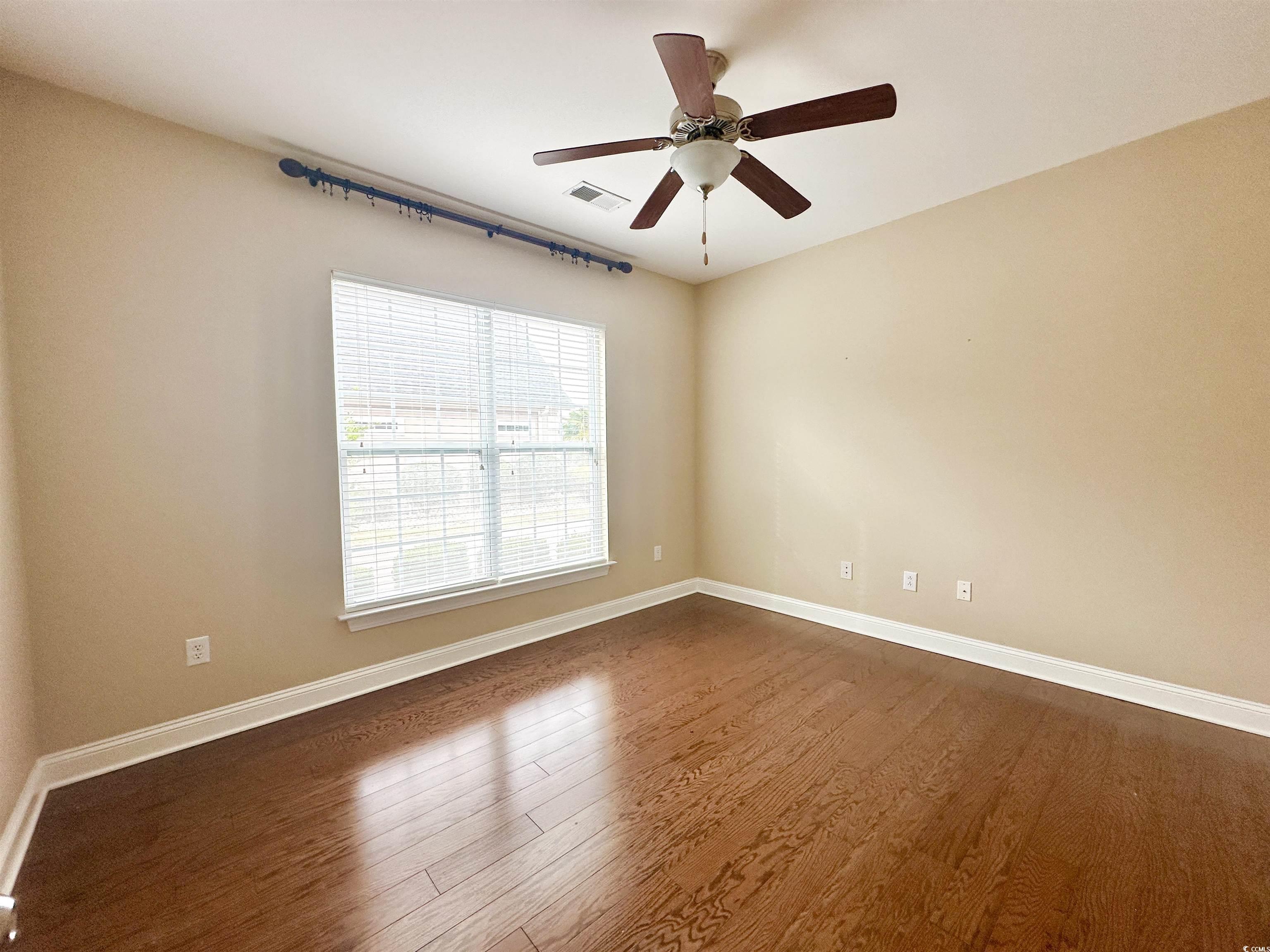 8472 Juxa Drive Myrtle Beach, SC 29579 - Photo 12 of 35 Unfurnished room with dark wood-style flooring and a ceiling fan