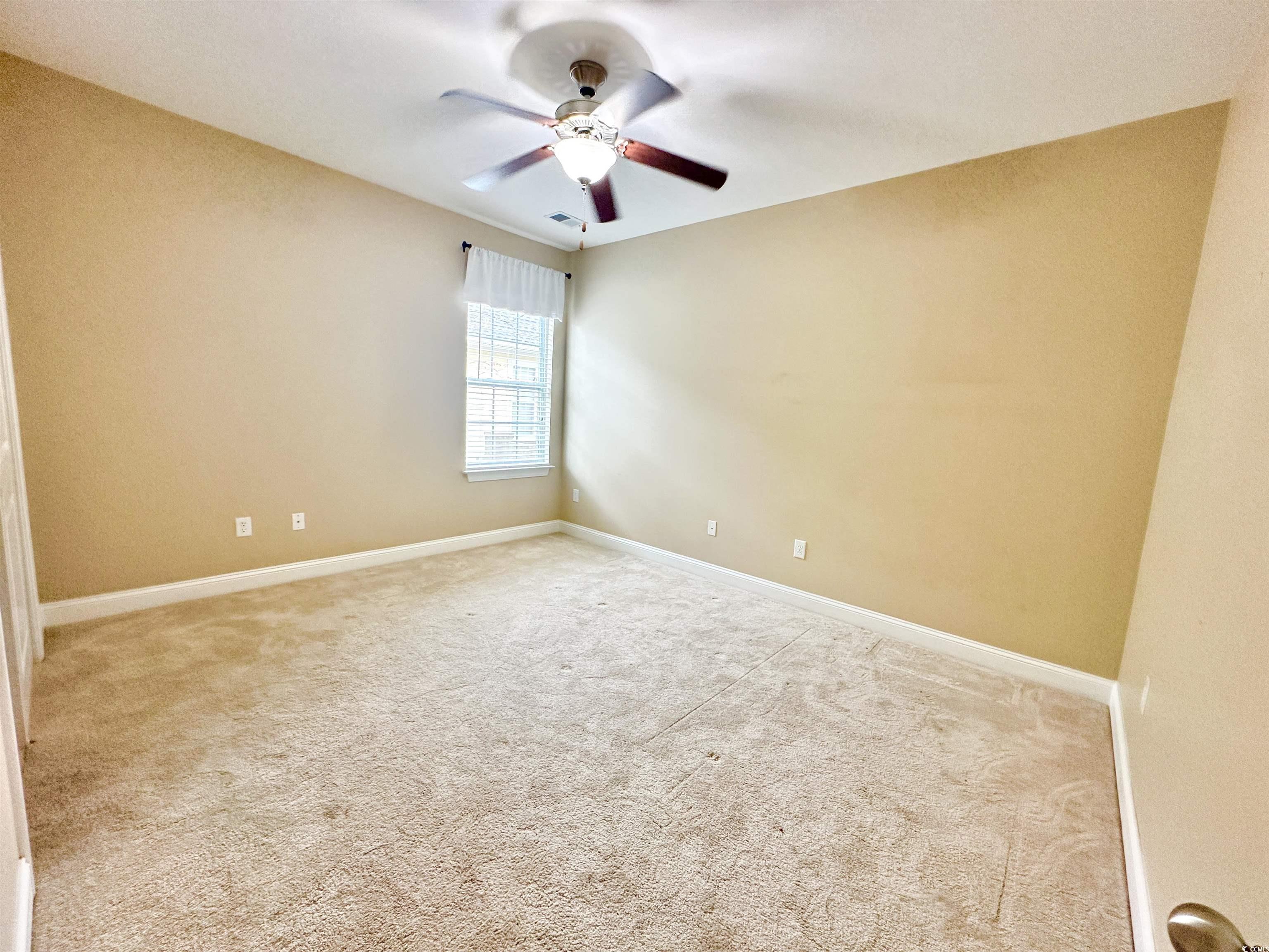 8472 Juxa Drive Myrtle Beach, SC 29579 - Photo 14 of 35 Spare room with light colored carpet and ceiling fan