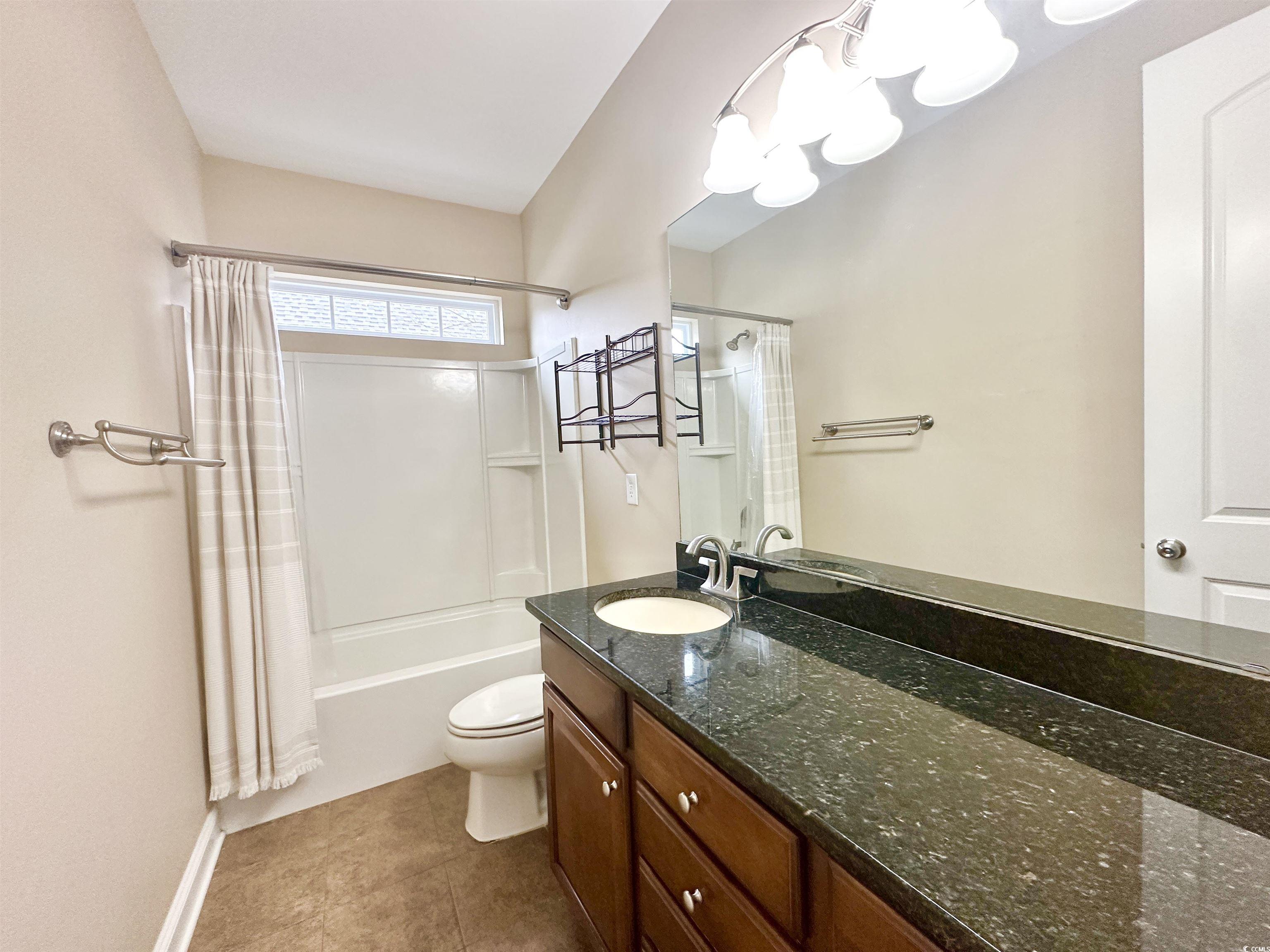 8472 Juxa Drive Myrtle Beach, SC 29579 - Photo 15 of 35 Full bath with shower / bathtub combination with curtain, vanity, and dark tile patterned flooring