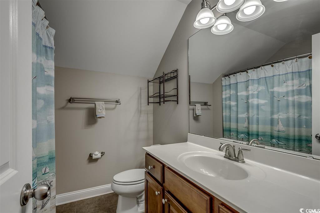 8472 Juxa Drive Myrtle Beach, SC 29579 - Photo 27 of 35 Bathroom featuring vanity, lofted ceiling, curtained shower, dark tile patterned flooring, and a chandelier