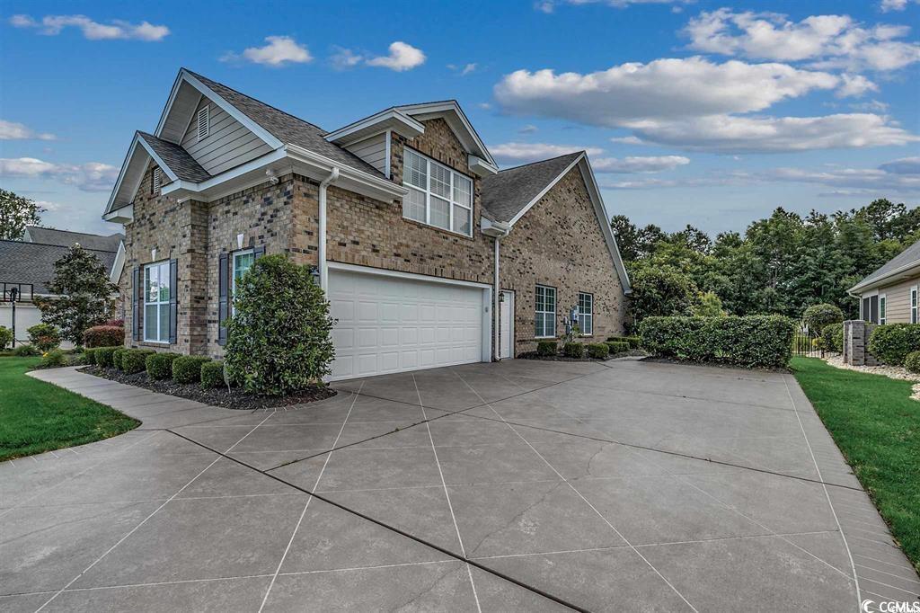 8472 Juxa Drive Myrtle Beach, SC 29579 - Photo 3 of 35 View of home's exterior with a garage, driveway, brick siding, and a yard