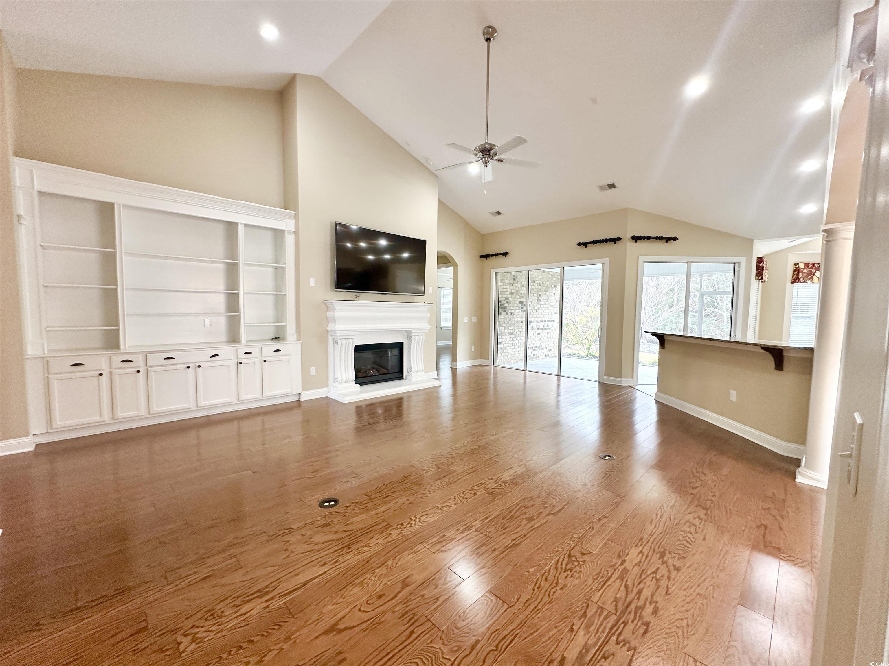 8472 Juxa Drive Myrtle Beach, SC 29579 - Photo 7 of 35 Unfurnished living room with a glass covered fireplace, high vaulted ceiling, light wood-style floors, ceiling fan, and recessed lighting