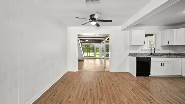 a view of a kitchen with wooden floor and a ceiling fan
