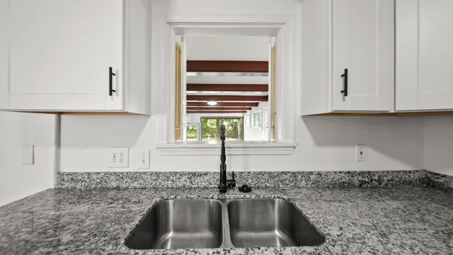 a kitchen with granite countertop a sink and a window
