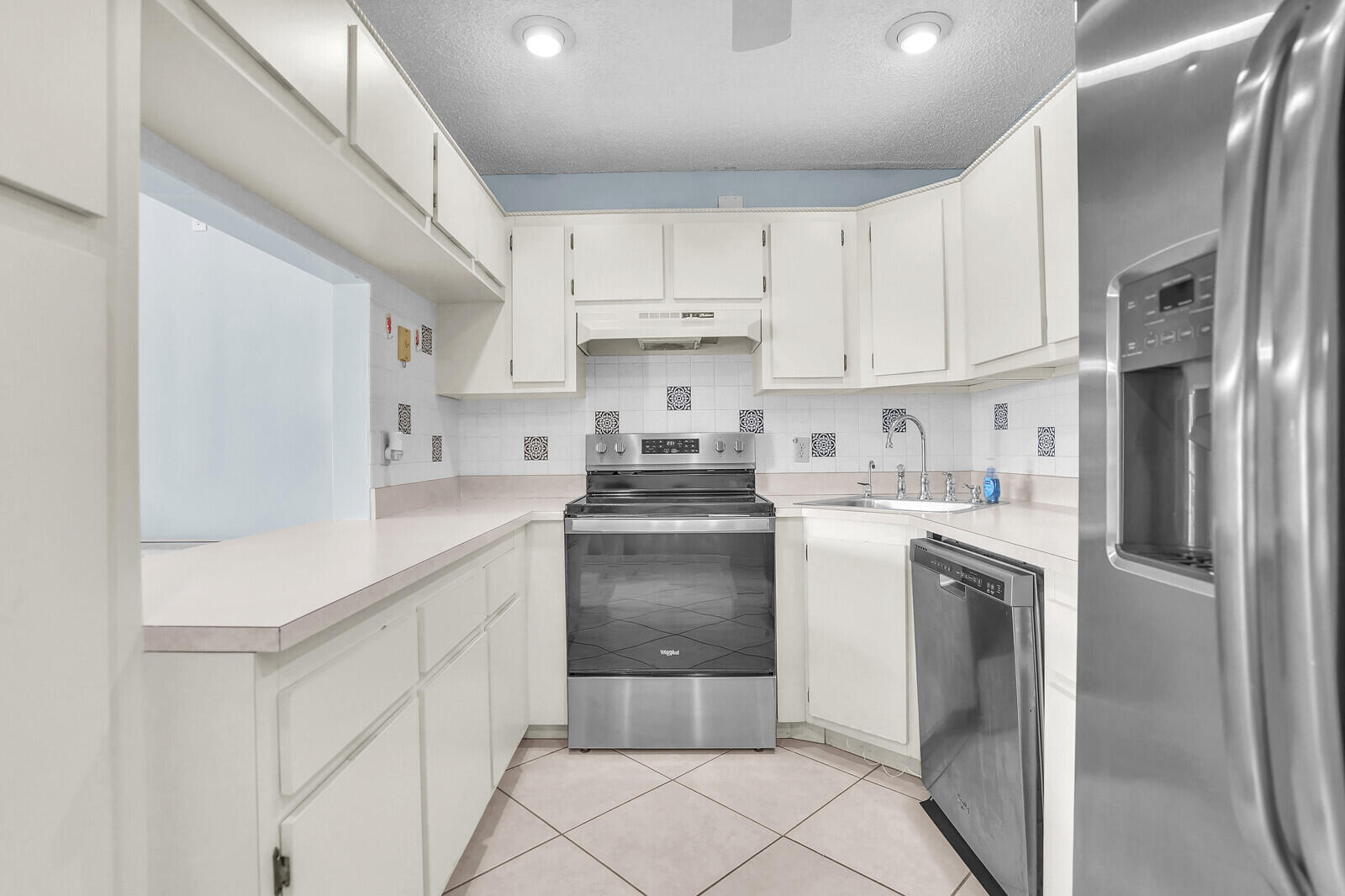 826 Sky Pine Way, Unit G2 Greenacres, FL 33415 - Photo 13 of 30 a kitchen with stainless steel appliances granite countertop a refrigerator sink and cabinets