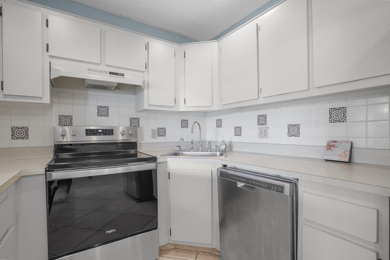 826 Sky Pine Way, Unit G2 Greenacres, FL 33415 - Photo 16 of 30 a kitchen with granite countertop white cabinets and white appliances