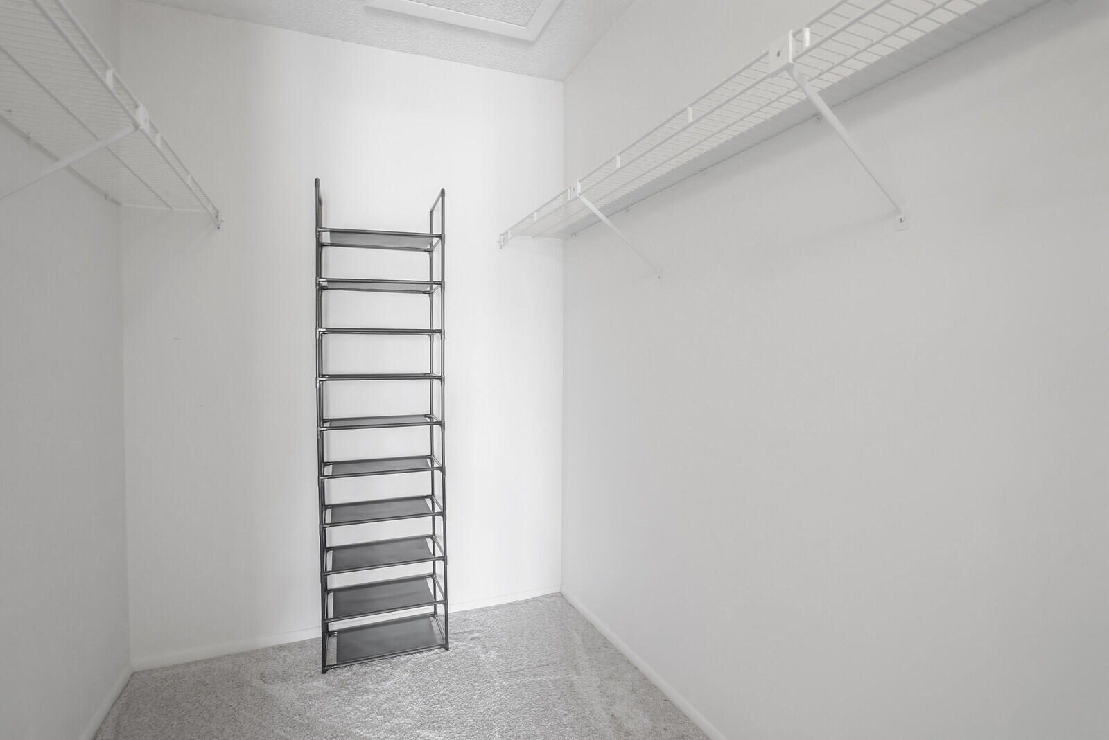 826 Sky Pine Way, Unit G2 Greenacres, FL 33415 - Photo 27 of 30 a view of walk in closet with empty racks