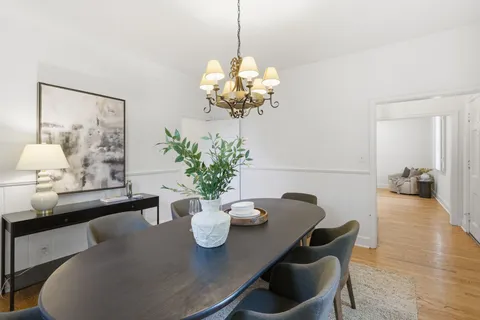a view of a dining room with furniture and chandelier