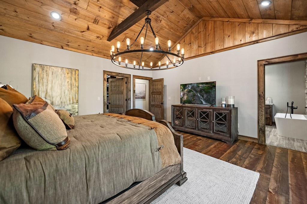 184 Spence Road Epworth, GA 30541 - Photo 31 of 62 a spacious bedroom with a bed a chandelier and flat screen tv