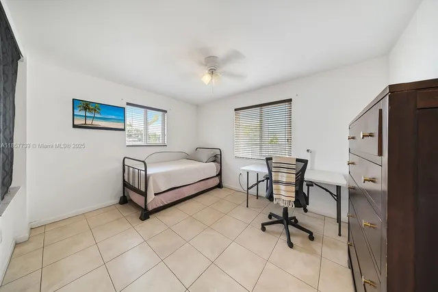 a bedroom with a bed a table and a dresser