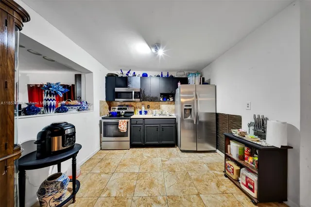 a kitchen with stainless steel appliances a refrigerator and a stove top oven