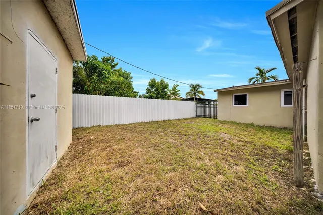 a view of house with backyard and wooden fence