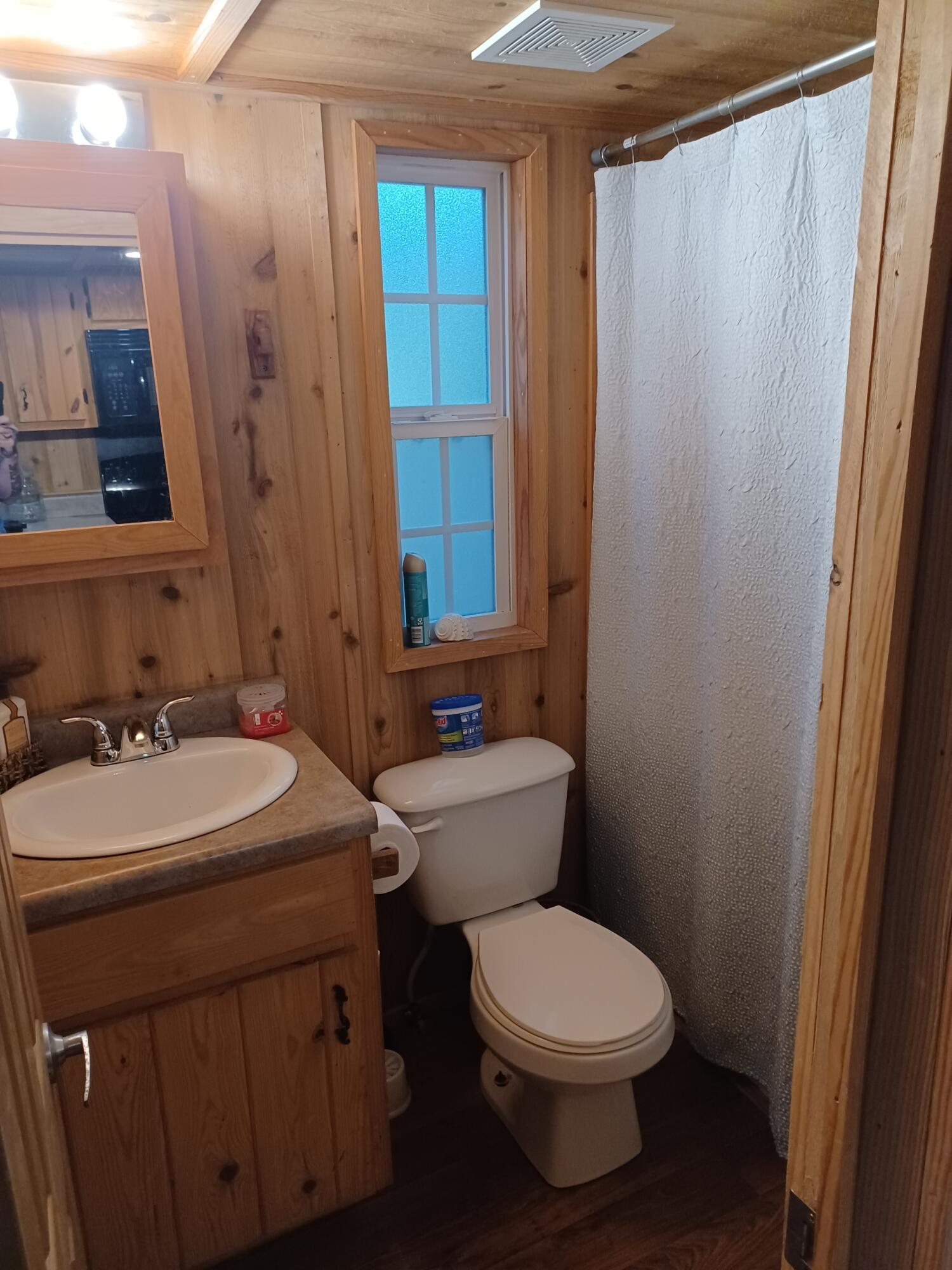 155 Madge Lane Santa Rosa Beach, FL 32459 - Photo 11 of 17 a bathroom with a toilet a sink and a mirror