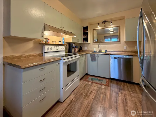 a kitchen with granite countertop a sink and steel appliances