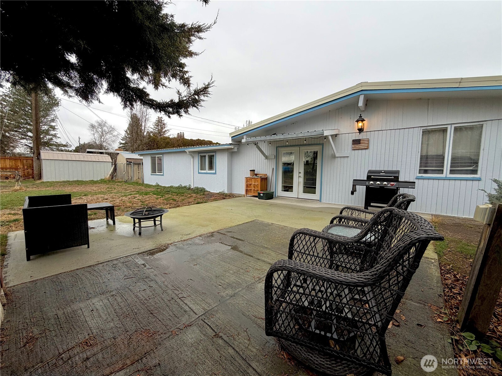 541 Fairchild Loop Moses Lake, WA 98837 - Photo 7 of 35 a view of a patio with couches table and chairs under an umbrella with a fire pit