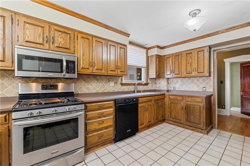 935 Alcoma Street Sharon, PA 16146 - Photo 17 of 28 a kitchen with stainless steel appliances granite countertop a stove microwave and cabinets