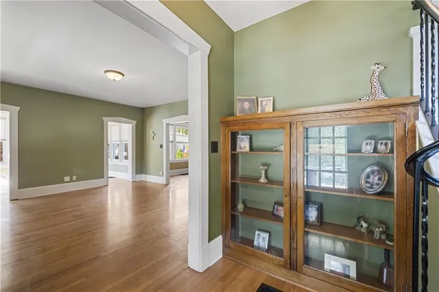 a view of an entrance and a livingroom with wooden floor