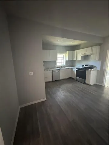 a kitchen with granite countertop white cabinets and stainless steel appliances