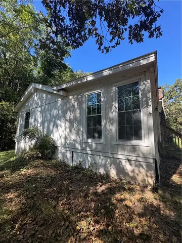 a view of a house with a small yard and floor to ceiling window