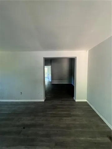 an empty room with wooden floor and windows in it