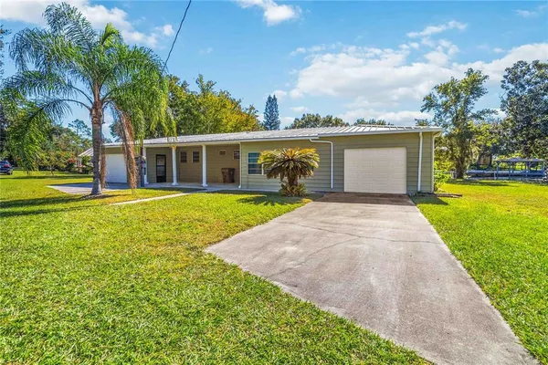 a view of a house with a yard and potted plants