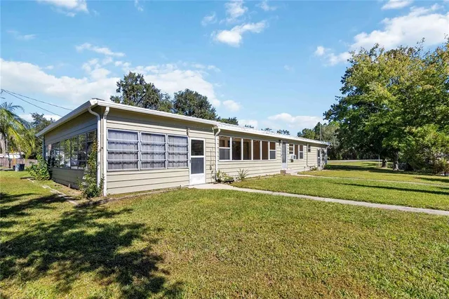a view of a house with backyard and sitting area