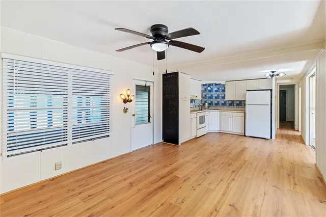 a view of a kitchen with wooden floor and a ceiling fan