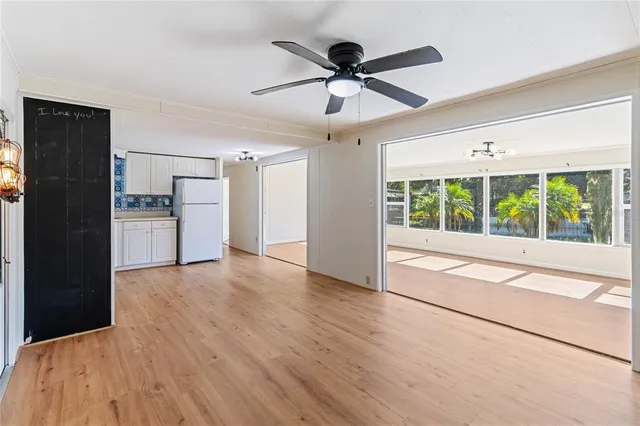 a view of a kitchen with a ceiling fan hardwood floor and a ceiling fan